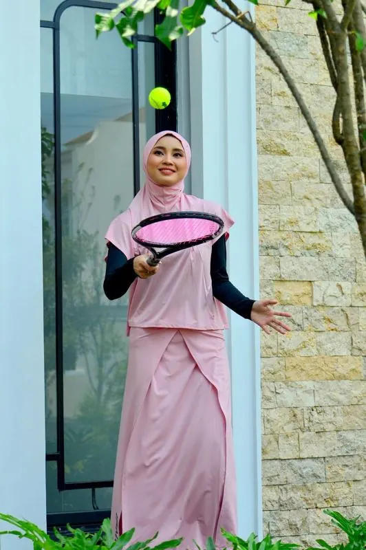 Perempuan berhijab bermain tenis